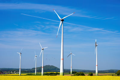 Low angle view of windmill against blue sky