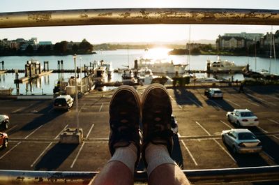 Low section of man on railing at harbor