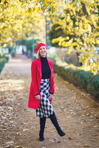 Portrait of young woman standing against trees