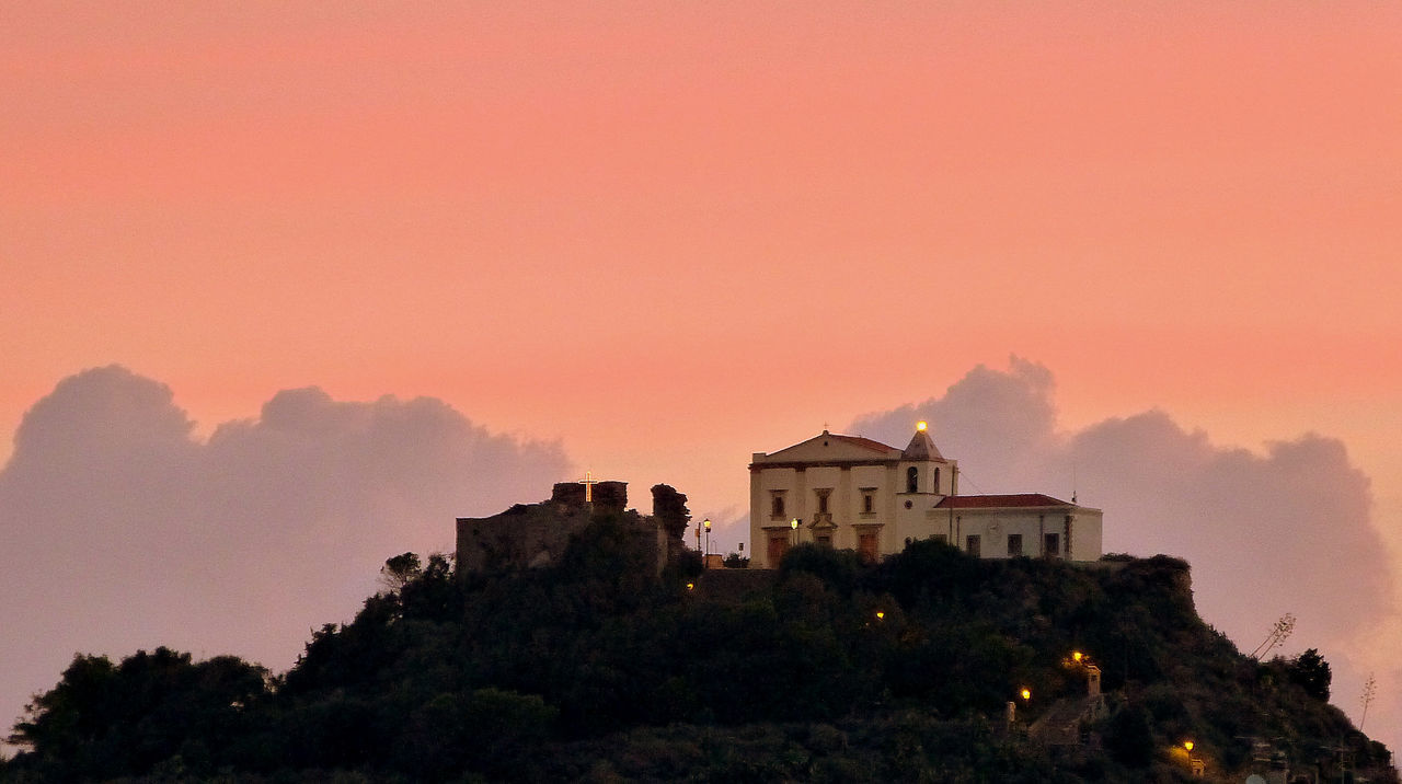 SILHOUETTE OF BUILDING AGAINST ORANGE SKY