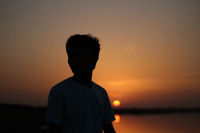 Silhouette man standing against sky during sunset