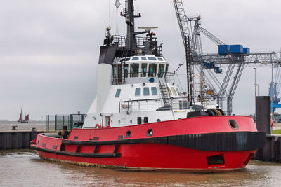 Ship moored at harbor against sky