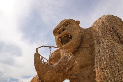 Low angle view of monkey statue against sky