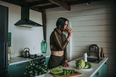 Midsection of woman standing at home