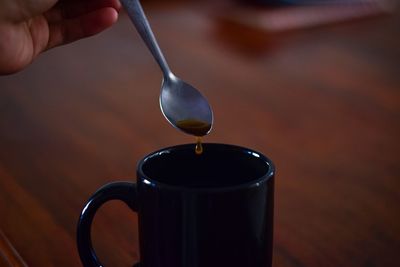 Close-up of hand pouring coffee in cup