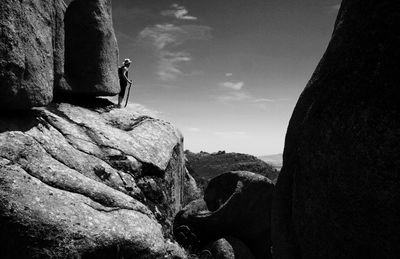 Man on rock against sky