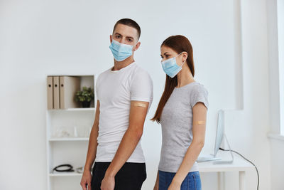 Young man and woman wearing mask at hospital