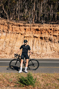 Low section of man riding bicycle on road