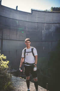 Full length of young man standing against built structure