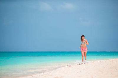 Full length of running on beach against sky