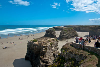 People on beach against blue sky