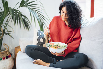 Brunette woman eating a healthy green salad.