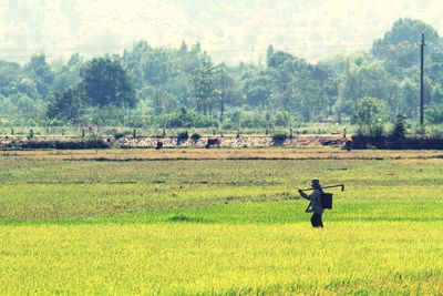 Men standing on field against trees