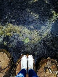 Low section of man standing on water