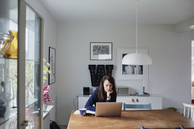 Young woman using laptop at home