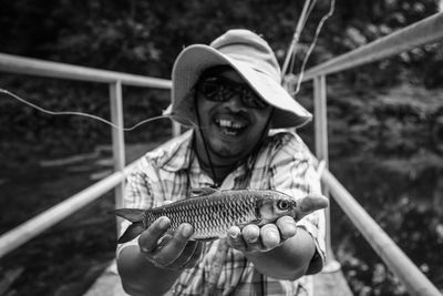 Portrait of smiling man holding fish