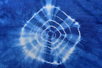 Macro shot of spider web against blue sky