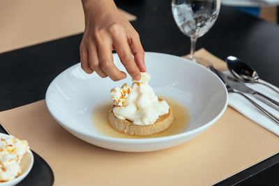 Midsection of man holding ice cream in plate on table