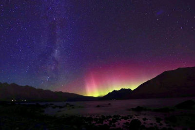 Scenic view of silhouette mountains against sky at night