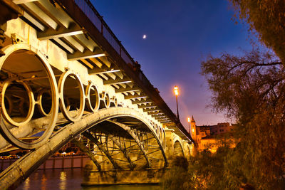 Low angle view of illuminated bridge against sky at night