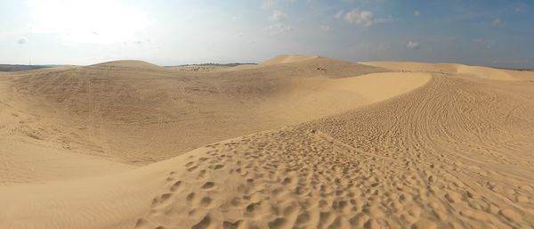 Sand dune at desert against sky