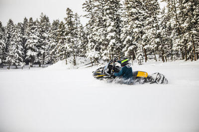 Man riding bicycle on snow covered field