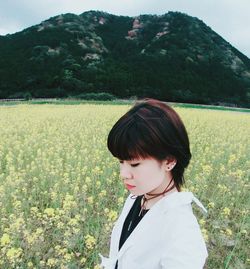 Side view of young woman standing on field