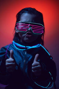 Portrait of a boy child from the future in neon glasses and jacket at night