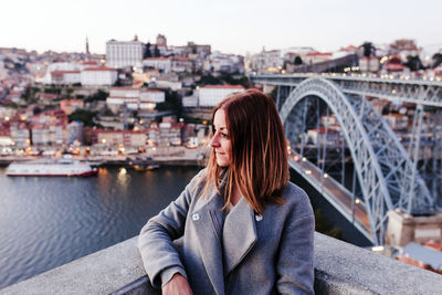 Young relaxed woman in porto bridge at sunset. tourism in city europe. travel and lifestyle