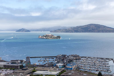 High angle view of city by sea against sky