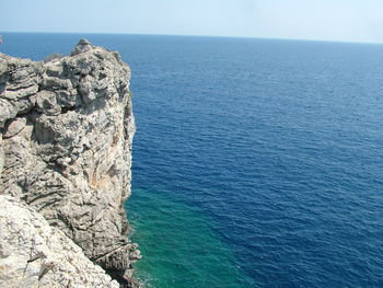 Rock formation in sea against sky