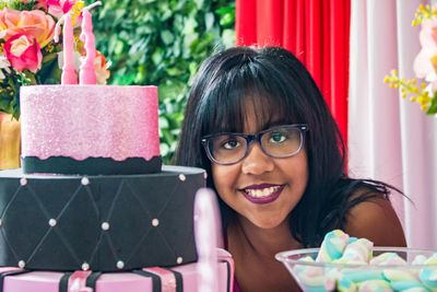 Portrait of smiling teenage girl with cake at table