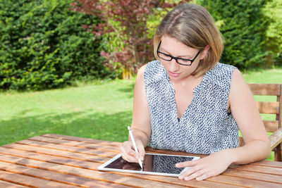 Young woman sitting on table in park