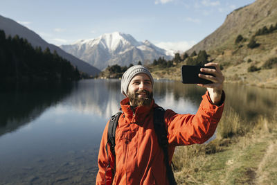 France, pyrenees, pic carlit, hiker taking a selfie at mountain lake