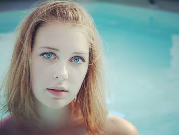 Portrait of young woman against swimming pool