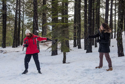 Full length of woman standing on snow covered land