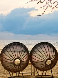 Umbrellas on beach against sky during sunset