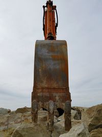 Low angle view of old rusty column against sky