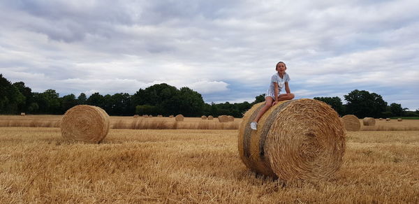 Hay bales on field against sky