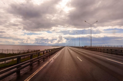 Empty road against cloudy sky