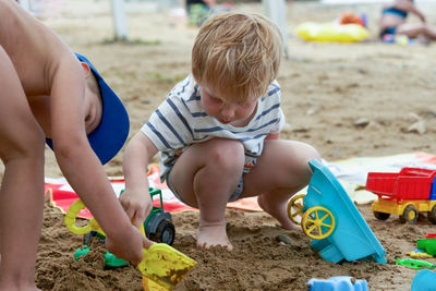 Portrait of boy playing with sand at beach