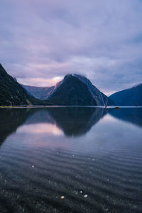 Scenic view of lake against mountains and cloudy sky