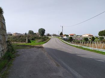 Road amidst trees against clear sky