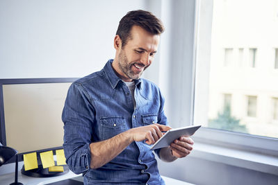 Smilig man using tablet in office