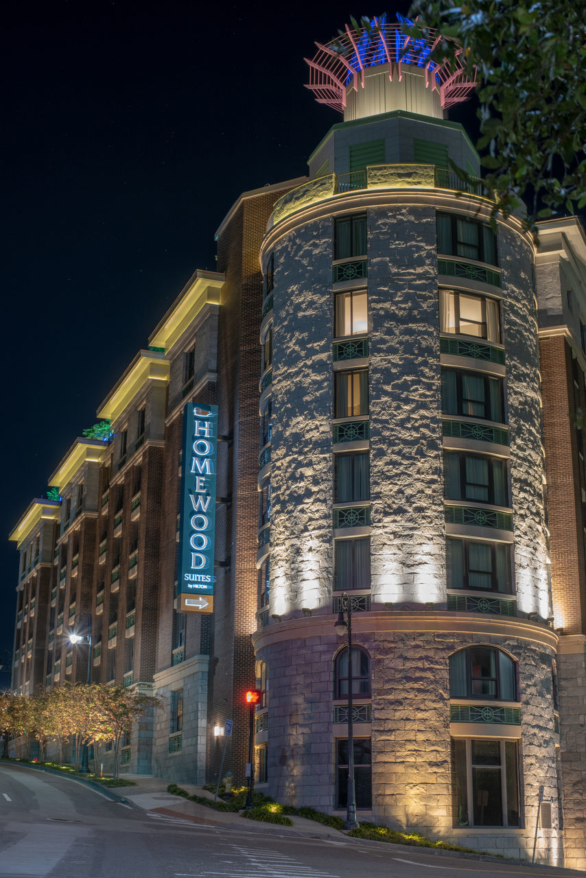 LOW ANGLE VIEW OF ILLUMINATED BUILDINGS AT NIGHT