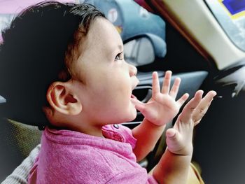 Close-up portrait of cute baby girl in car