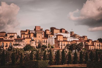 Buildings in city against cloudy sky