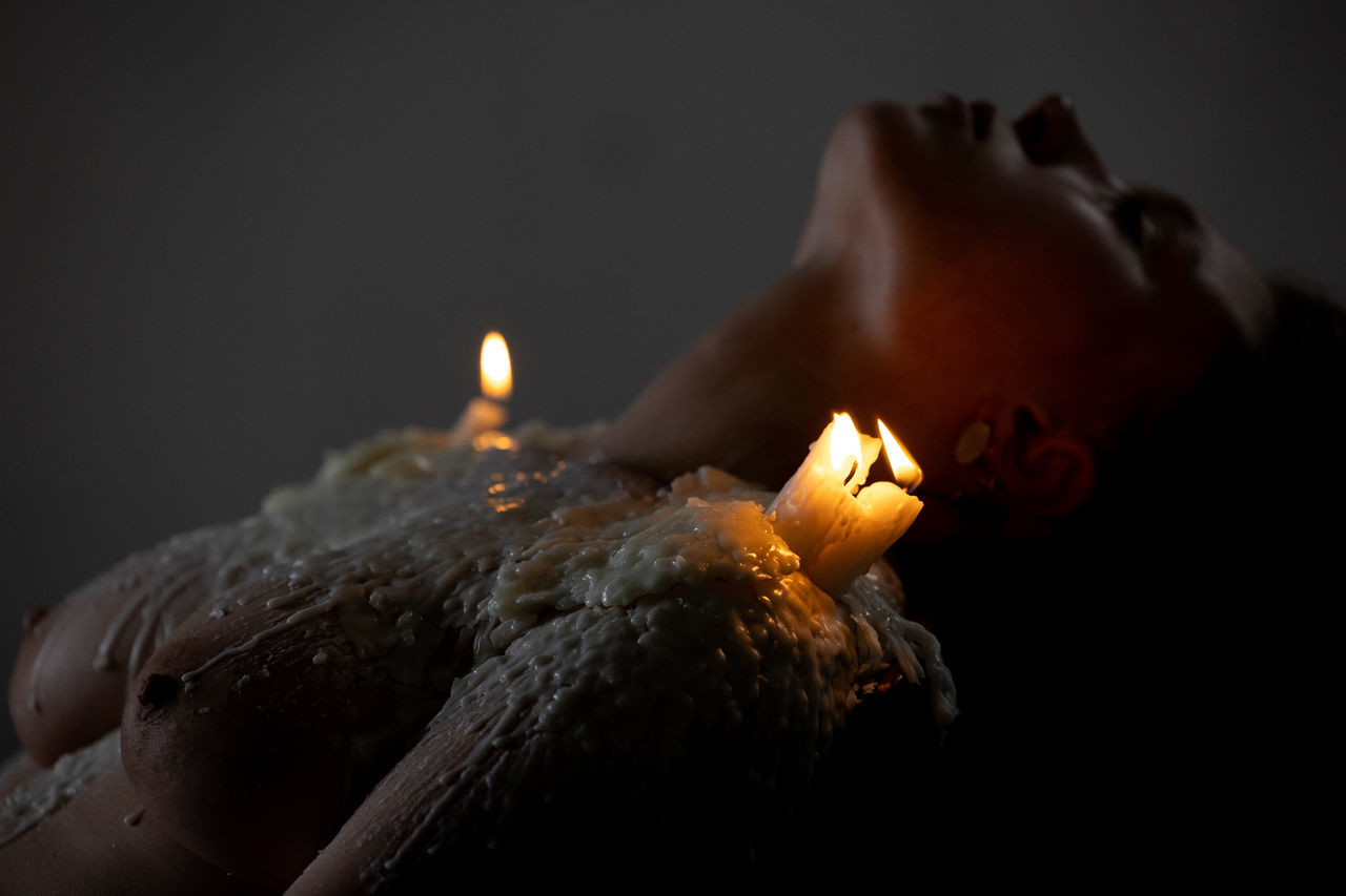 burning, fire, flame, candle, darkness, birthday cake, light, heat, macro photography, indoors, nature, illuminated, close-up, glowing, dark, one person, religion, lighting, black background, spirituality, studio shot, belief, hand, celebration, night