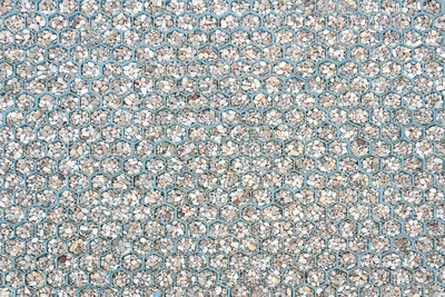 The sidewalk in the form of honeycombs is paved with small stones, pebbles. background or texture