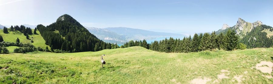 Scenic view of green landscape and mountains against clear sky